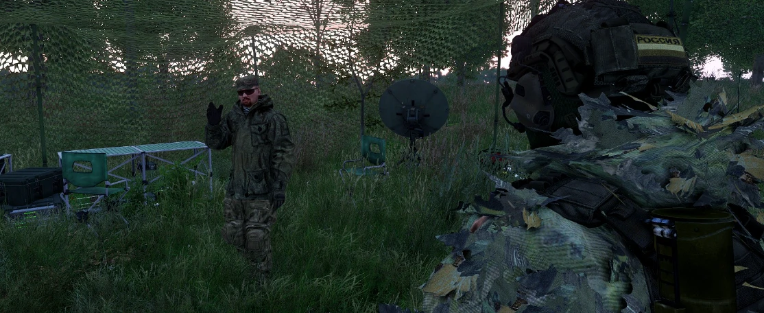 Camouflaged command post under netting with a satellite dish